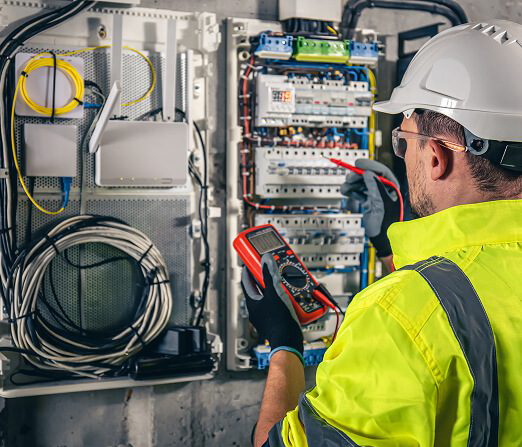 Electrician inspecting and testing hazardous-area electrical control panel and instrumentation systems